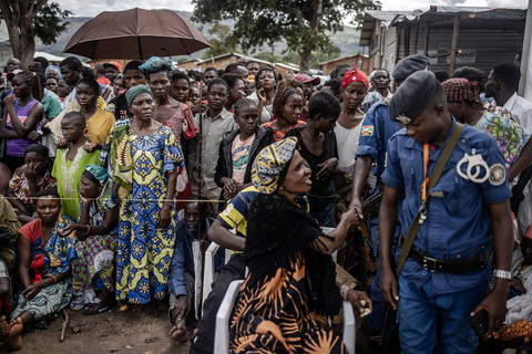 Pengungsi Kongo berkumpul menunggu kesempatan untuk menerima makanan saat polisi Burundi memantau daerah tersebut selama operasi distribusi makanan di lokasi pengungsian Musenyi di Giharo, pada 7 Mei 2025. Foto: Luis TATO / AFP