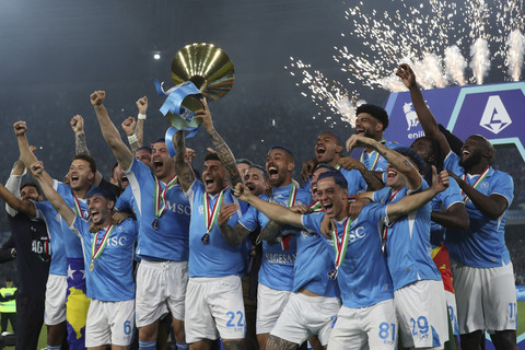 Sejumlah pemain dan ofisial tim Napoli FC berselebrasi dengan mengangkat trofi usai memastikan juara pada pertandingan Liga Italia melawan Cagliari di Stadion Maradona, Naples, Italia, Jumat (23/5/2025). Foto: Carlo Hermann/AFP