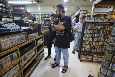 Calon pembeli memilih rilisan musik 'fisik' seperti piringan hitam, kaset dan cd di Blok M Square, Jakarta, Sabtu (24/5/2025). Foto: Iqbal Firdaus/kumparan