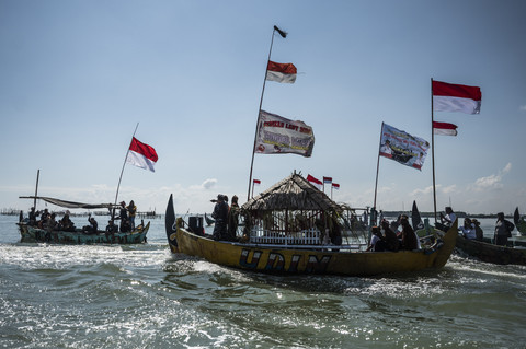 Warga menggunakan kapal ke tengah laut untuk mengikuti persembahan dalam tradisi sedekah laut dan bumi di perairan Laut Tanjung Emas, Semarang, Jawa Tengah, Minggu (5/25/2025). Foto: Foto Aprillio Akbar/Antara