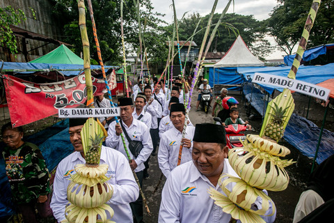 Karyawan membawa tebu yang di hias saat kirab temanten tebu pada tradisi Cembrengan atau menyambut musim giling tebu di Pabrik Gula (PG) Mojo. Foto: Mohammad Ayudha/ANTARA FOTO