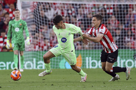 Pemain FC Barcelona, Pedri, beraksi dengan pemain Athletic Bilbao, Inigo Ruiz de Galarreta pada pertandingan Liga Spanyol antara Athletic Bilbao vs FC Barcelona di San Mames, Bilbao, Spanyol, Senin (26/5/2025) dini hari WIB. Foto: PANKRA NIETO/REUTERS