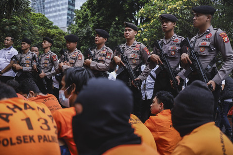 Polisi berjaga saat sejumlah tahanan dihadirkan dalam konferensi pers kasus kejahatan hasil Operasi Brantas Jaya 2025 di Polda Metro Jaya, Senin (26/5/2025). Foto: Jamal Ramadhan/kumparan