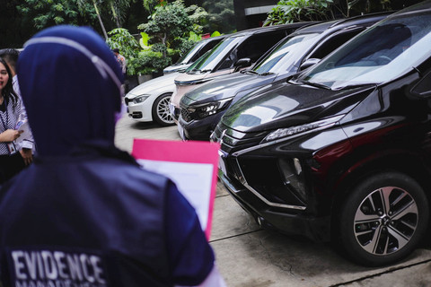 Petugas KPK melihat kondisi kendaraan yang disita oleh KPK dari penggeledahan terkait kasus dugaan korupsi Kemenaker di Gedung Merah Putih KPK, Jaksel, Senin (26/5/2025). Foto: Jamal Ramadhan/kumparan