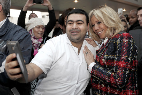 Brigitte Macron mengenakan jaket tweed dari Balmain saat mendampingi Emmanuel Macron dalam kunjungan ke rumah sakit di Saint-Denis untuk memperingati Hari AIDS Sedunia pada Desember 2017. Foto: AFP