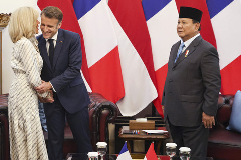 Presiden Prancis Emmanuel Macron berpelukan dengan istrinya Brigitte Macron dengan disaksikan Presiden Prabowo Subianto saat melakukan pertemuan bilateral di Istana Merdeka, Jakarta, Rabu (28/5/2025). Foto: Ludovic Marin/AFP
