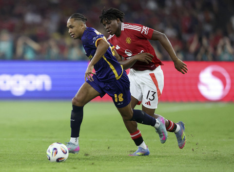 Pemain ASEAN All Star Kealey Adamson menggiring bola melewati pemain Manchester United Patrick Dorgu pada pertandingan persahabatan di Stadion Bukit Jalil, Malaysia, Rabu (28/5/2025). Foto: Hasnoor Hussain/Reuters