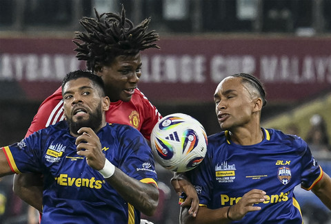 Pemain Manchester United Patrick Dorgu berebut bola dengan dua pemain ASEAN All Star pada pertandingan persahabatan di Stadion Bukit Jalil, Malaysia, Rabu (28/5/2025). Foto: Mohd Rasfan/AFP