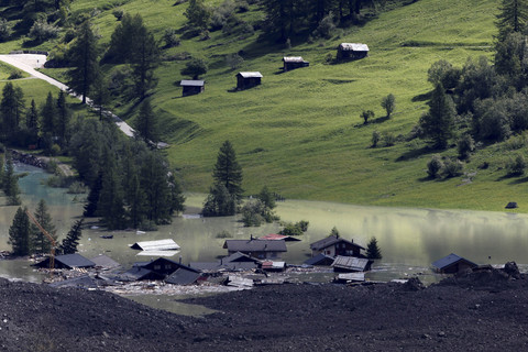 Beberapa rumah yang tersisa terlihat setelah longsor batu dan es besar menutupi sebagian besar desa Blatten, Swiss, Kamis (29/5/2025). Foto: Stefan Wermuth/REUTERS  