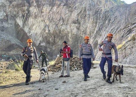 Personil polisi membawai anjing pelacak K-9 di area sekitar lokasi tanah longsor di galian C Gunung Kuda di Kabupaten Cirebon, Jawa Barat, Sabtu (31/5/2025). Foto: kumparan