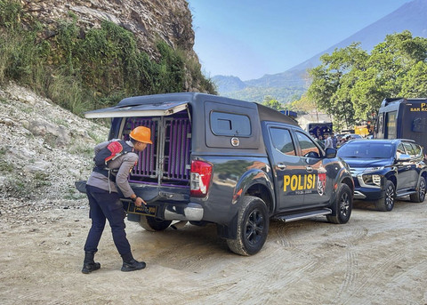 Personil polisi membawai anjing pelacak K-9 di area sekitar lokasi tanah longsor di galian C Gunung Kuda di Kabupaten Cirebon, Jawa Barat, Sabtu (31/5/2025). Foto: kumparan