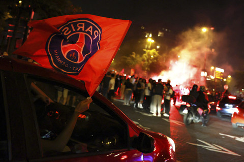 Penggemar Paris St Germain melambaikan bendera dari jendela mobil setelah menjuarai Liga Champions di Paris, Prancis, Sabtu (31/5/2025). Foto: Tom Nicholson/REUTERS