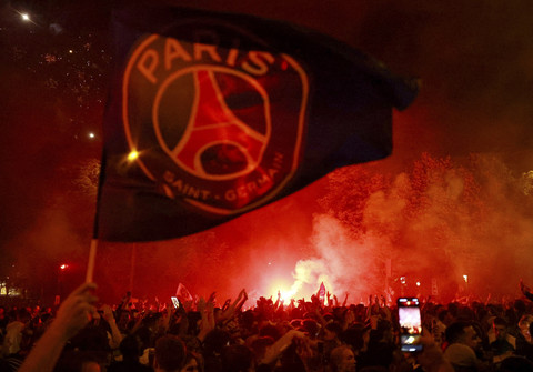 Penggemar Paris St Germain melambaikan bendera setelah menjuarai Liga Champions di Paris, Prancis, Sabtu (31/5/2025). Foto: Lisi Niesner/REUTERS