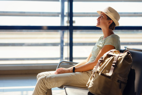Penumpang duduk di kursi bandara. Foto: Shutterstock
