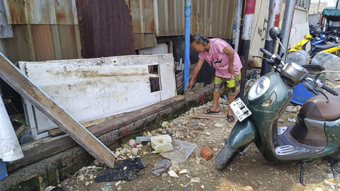 Darsinah (65) menunjukkan sisa tanggul laut yang dulu setinggi 2 meter, pembatas antara empang dengan laut, Penjaringan, Jakarta Utara, Senin (2/6/2025). Foto: Thomas Bosco/kumparan