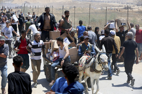 Warga Palestina mengendarai gerobak yang ditarik keledai saat menerima pasokan bantuan dari yayasan kemanusiaan Gaza di Jalur Gaza Tengah, Kamis (29/5/2025). Foto: Ramadan Abed/REUTERS