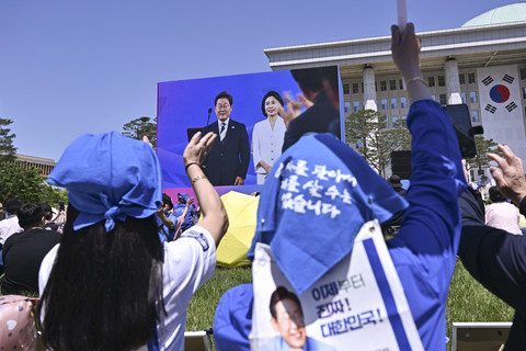 Sejumlah warga menyaksikan upacara pelantikan Presiden Korea Selatan terpilih Lee Jae-myung di luar Majelis Nasional, Seoul, Korea Selatan, Rabu (4/6/2025). Foto: Pedro Pardo/AFP