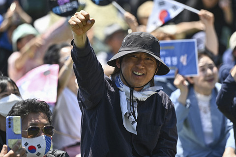 Sejumlah warga menyaksikan upacara pelantikan Presiden Korea Selatan terpilih Lee Jae-myung di luar Majelis Nasional, Seoul, Korea Selatan, Rabu (4/6/2025). Foto: Pedro Pardo/AFP