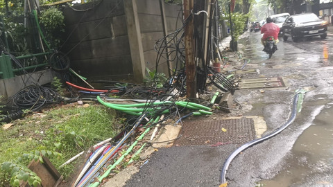 Potret kesemerawutan kabel-kabel tanam yang menyembul dari tanah dan saluran air di Jalan Kuningan Barat Raya, Jakarta Selatan, Rabu (4/6/2025). Foto: Thomas Bosco/kumparan