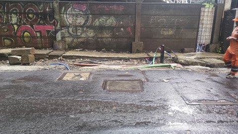 Potret kesemerawutan kabel-kabel tanam yang menyembul dari tanah dan saluran air di Jalan Kuningan Barat Raya, Jakarta Selatan, Rabu (4/6/2025). Foto: Thomas Bosco/kumparan
