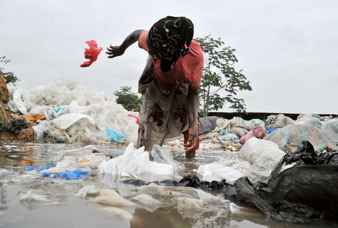 Seorang perempuan membersihkan kantong plastik yang akan didaur ulang di Yopougon, sebuah wilayah pinggiran Abidjan, pada 2 September 2013. Mengikuti jejak Rwanda dan Mauritania, otoritas di Pantai Gading memutuskan untuk melarang produksi, penggunaan, dan perdagangan kantong plastik pada akhir tahun ini. FOTO AFP / ISSOUF SANOGO