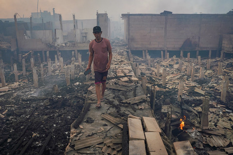 Warga berada di antara puing-puing rumah yang hangus dalam kebakaran permukiman padat penduduk di Jalan Kapuk Raya, Kapuk Muara, Penjaringan, Jakarta, Jumat (6/6/2025). Foto: ANTARA FOTO/Ferlian Septa Wahyusa