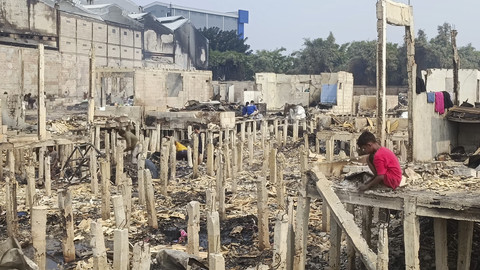 Seorang bocah berada di antara puing-puing rumah yang hangus dalam kebakaran permukiman padat penduduk di Jalan Kapuk Raya, Kapuk Muara, Penjaringan, Jakarta, Sabtu (7/6/2025). Foto: Thomas Bosco/kumparan