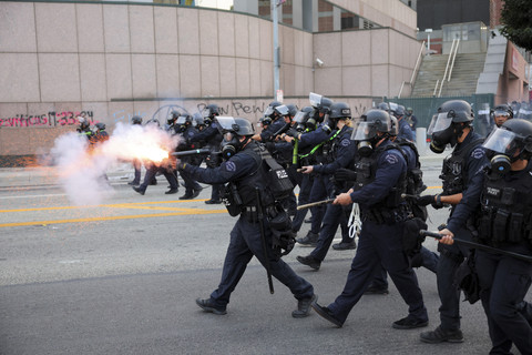 Petugas kepolsiian menembaki gas air mata ke arah demonstran dalam unjuk rasa di depan Gedung Federal Los Angeles, Amerika Serikat, Jumat (6/6/2025). Foto: Daniel Cole/Reuters