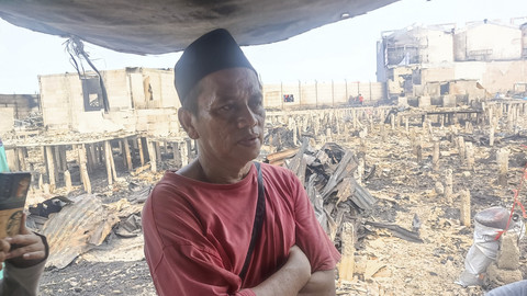 Edi (55) warga korban kebakaran Kapuk Muara yang menjaga puing-puing rumahnya agar tidak dijarah di Jalan Kapuk Raya, Kapuk Muara, Penjaringan, Jakarta, Sabtu (7/6/2025). Foto: Thomas Bosco/kumparan