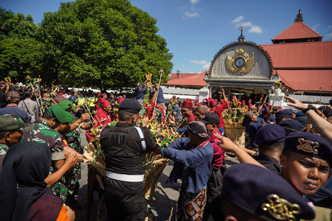 Abdi dalem membagikan isi gunungan saat Grebeg Besar di Masjid Gedhe Kauman, Yogyakarta, Sabtu (7/6/2025). Foto: ANTARA FOTO/Hendra Nurdiyansyah