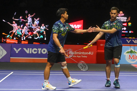 Pebulu tangkis ganda putra Indonesia Sabar Karyaman Gutama (kiri) dan Reza Pahlevi Isfahani (kanan) melakukan tos usai meraih poin atas lawannya ganda putra Malaysia Man Wei Chong/Tee Kai Wun pada babaksemi final Kapal Api Indonesia Open 2025. Foto: ANTARA FOTO/Rivan Awal Lingga