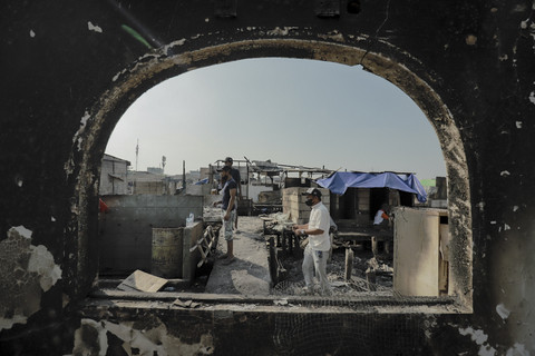 Warga melintas di lokasi kebakaran permukiman padat penduduk di Jalan Kapuk Raya, Kapuk Muara, Penjaringan, Jakarta, Minggu (8/6/2025). Foto: Jamal Ramadhan/kumparan