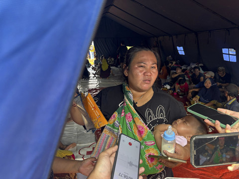 Sari (34), salah satu warga korban kebakaran di Penjaringan, Jakarta Utara yang mengungsi di tenda pengungsian pada Minggu (8/6/2025).  Foto: Abid Raihan/kumparan