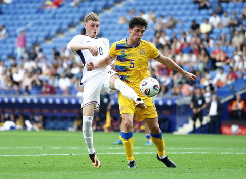 Pemain Timnas Inggris Cole Palmer berebut bola dengan pemain Timnas Andorra Max Llovera pada pertandingan Kualifikasi Piala Dunia 2026 zona Eropa di Stadion RCDE, Cornella de Llobregat, Spanyol, Sabtu (7/6/2025). Foto: Peter Cziborra/Reuters