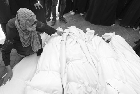 Warga Palestina menangis di depan jenazah kepada korban serangan Israel di rumah sakit Al-Shifa, Gaza, Sabtu (7/6/2025). Foto: Mahmoud Issa/REUTERS