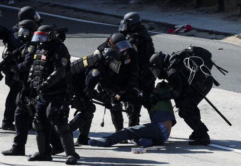Petugas kepolisian menahan seorang demonstran saat melakukan aksi protes menentang razia imigrasi federal di pusat kota Los Angeles, California, AS, Minggu (8/6/2025). Foto: Mike Blake/REUTERS