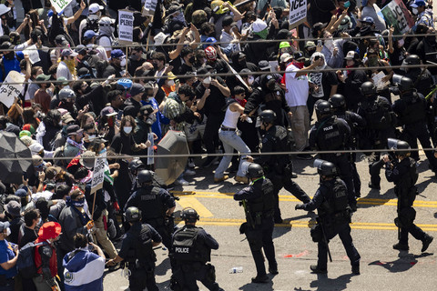 Aparat keamanan bentrok dengan para demonstran di depan gedung federal dalam sebuah protes terhadap operasi imigrasi federal, di Los Angeles, California, Minggu (8/6/2025). Foto: ETIENNE LAURENT/AFP