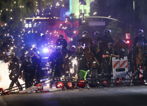 Petugas kepolisian berjaga-jaga saat aksi protes menentang razia imigrasi federal di pusat kota Los Angeles, California, AS, Minggu (8/6/2025). Foto: Aude Guerrucci/REUTERS