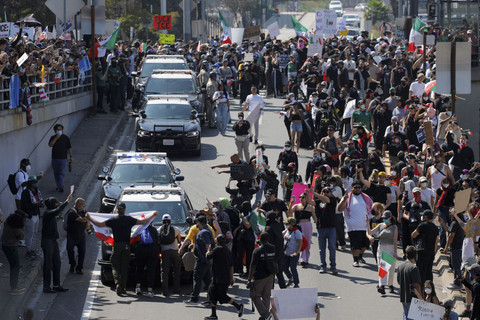 Para demonstran memblokir jalan saat mereka mencoba menghentikan kendaraan penegak hukum untuk masuk ke jalan raya, dalam sebuah protes menentang razia imigrasi federal di pusat kota Los Angeles, California, A.S, Minggu (8/6/2025). Foto: Mike Blake/REUTERS