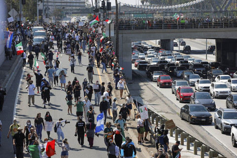 Para demonstran berjalan menuju jalan raya, saat melakukan aksi protes menentang razia imigrasi federal di pusat kota Los Angeles, California, AS, Minggu (8/6/2025). Foto: Mike Blake/REUTERS