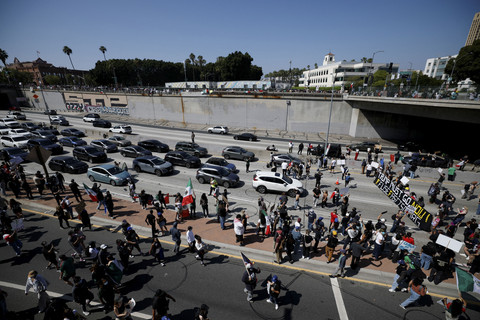 Para demonstran memblokir jalan raya, saat melakukan aksi protes menentang razia imigrasi federal di pusat kota Los Angeles, California, AS, Minggu (8/6/2025). Foto: Mike Blake/REUTERS