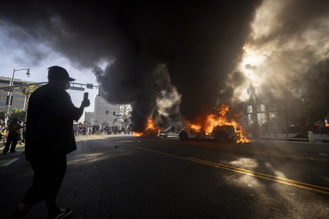 Mobil-mobil Waymo dibakar ketika para pengunjuk rasa bentrok dengan penegak hukum di dekat gedung federal dalam sebuah protes untuk menanggapi operasi imigrasi federal di Los Angeles, California, Minggu (8/6/2025). Foto: ETIENNE LAURENT/AFP
