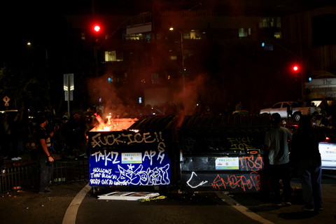 Vandalisme di sebuah gedung selama protes terhadap razia imigrasi federal di pusat kota Los Angeles, California, AS, Minggu (8/6/2025). Foto: David Swanson/REUTERS