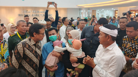 Menteri Kesehatan Budi Gunadi Sadikin dan Gubernur Jawa Barat Dedi Mulyadi menggendong anak kembar siam, Nadia dan Nadira, di RSHS Bandung, Jawa Barat, Selasa (10/6). Foto: Alya Zahra/kumparan
