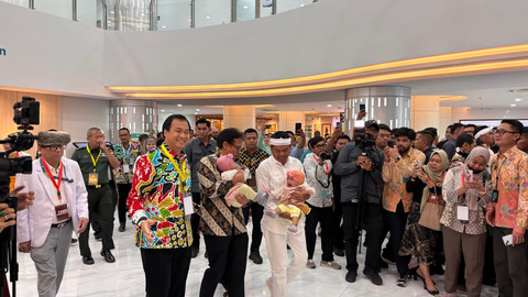 Menteri Kesehatan Budi Gunadi Sadikin dan Gubernur Jawa Barat Dedi Mulyadi menggendong anak kembar siam, Nadia dan Nadira, di RSHS Bandung, Jawa Barat, Selasa (10/6). Foto: Alya Zahra/kumparan