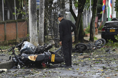 Seorang anggota tim penjinak bom berdiri di lokasi ledakan sepeda motor di depan kantor polisi di lingkungan Melendez, di Cali, Kolombia, Selasa (10/6/2025). Foto: Stringer/REUTERS