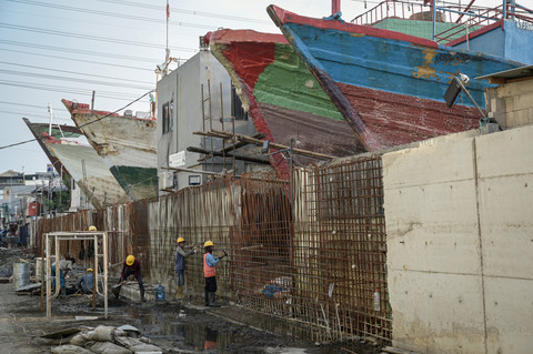 Sejumlah pekerja menyelesaikan pembangunan tanggul mitigasi di area Docking Kapal Baywalk, Pluit, Jakarta, Rabu (11/6/2025). Foto: Fauzan/ANTARA FOTO