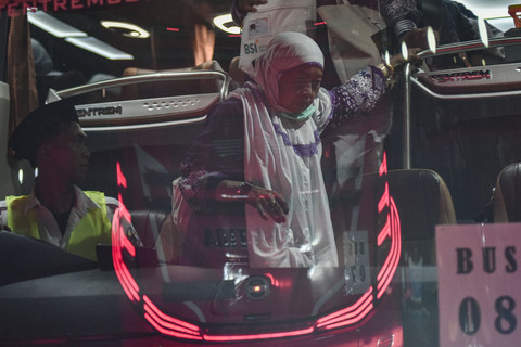 Jemaah haji bersiap turun dari bus saat tiba di Aula Asrama Haji Embarkasi Jakarta, Pondok Gede, Jakarta Timur, Kamis (12/6/2025). Foto: Fakhri Hermansyah/ANTARA FOTO