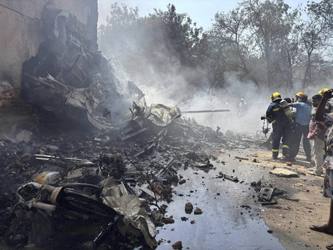 Petugas pemadam kebakaran bekerja di lokasi pesawat yang jatuh di kota Ahmedabad, negara bagian Gujarat, India barat laut, Kamis (12/6/2025). Foto: Ajit Solanki/AP Photo