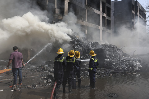 Anggota tim penyelamat bekerja saat asap mengepul di lokasi jatuhnya pesawat Air India di Ahmedabad, India, Kamis (12/6/2025). Foto: Amit Dave/REUTERS